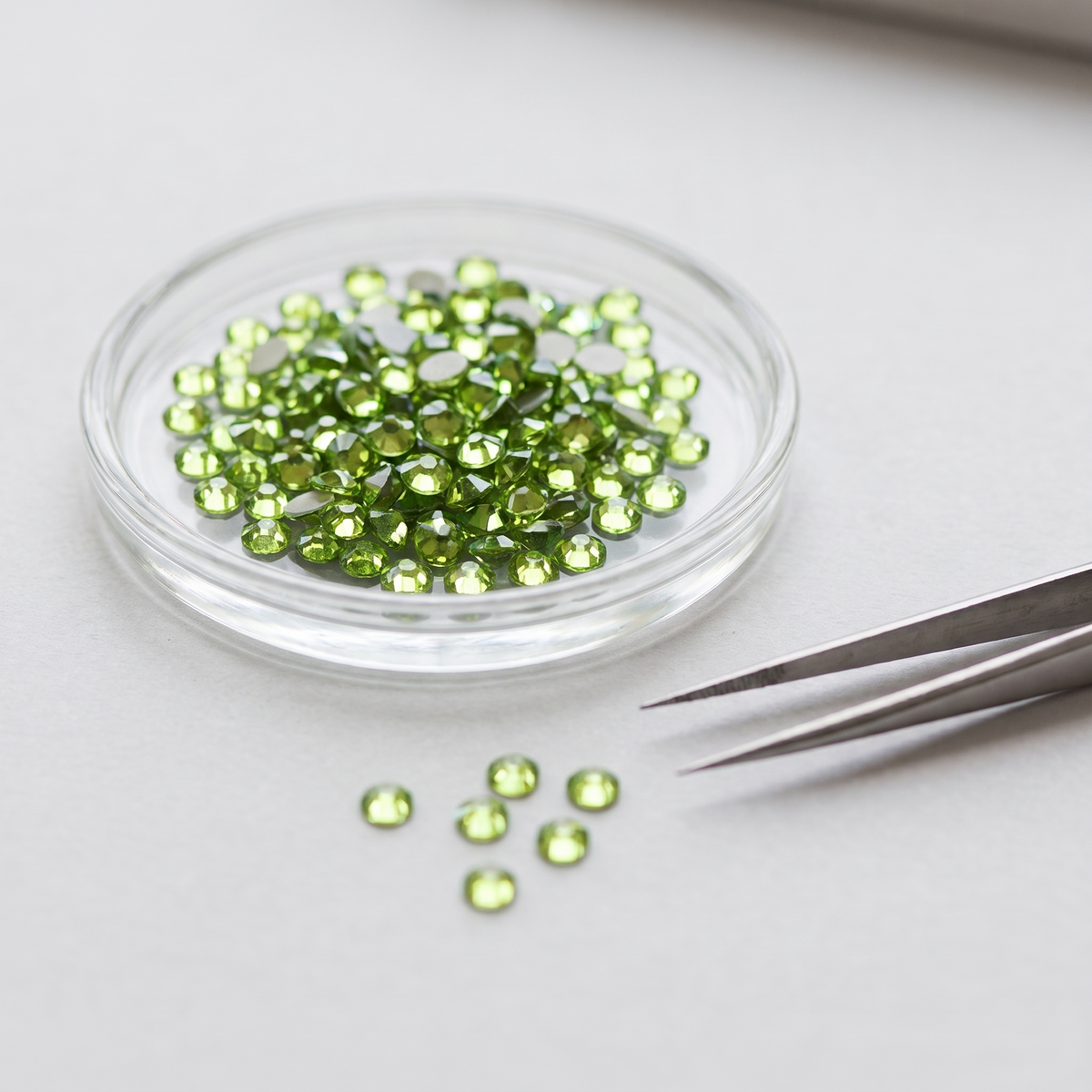Peridot Hot Fix Rhinestones in a glass dish
